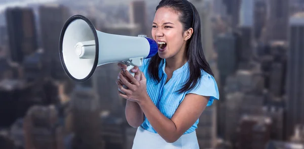Businesswoman shouting into a megaphone — Stock Photo, Image