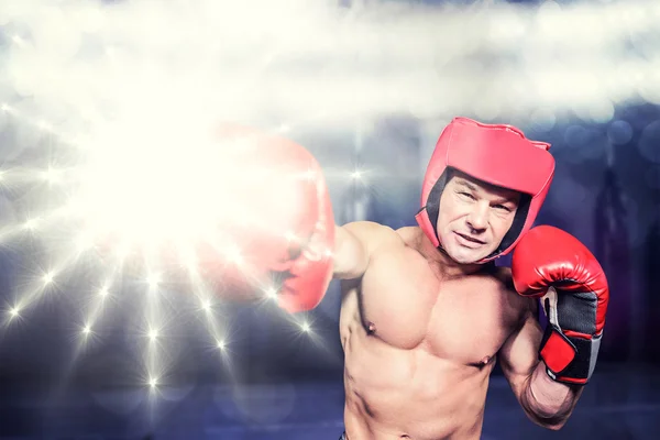 Boxer boxt vor schwarzem Hintergrund gegen roten Boxplatz — Stockfoto