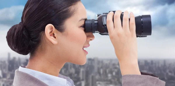 Zakenvrouw kijkt door verrekijker — Stockfoto