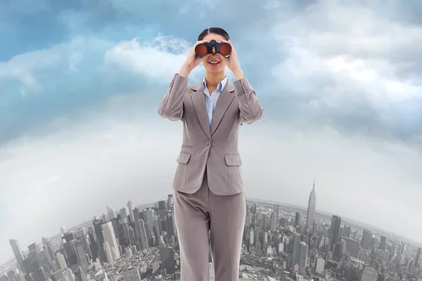 Businesswoman looking through binoculars — Stock Photo, Image