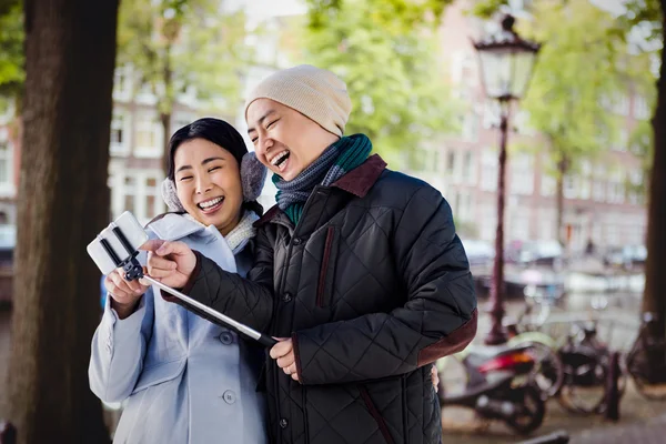 Pareja riendo de sus fotos tomadas en el teléfono inteligente — Foto de Stock