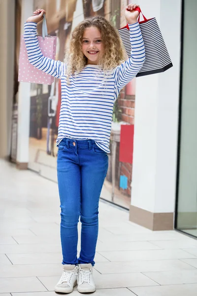 Menina feliz segurando sacos de compras — Fotografia de Stock