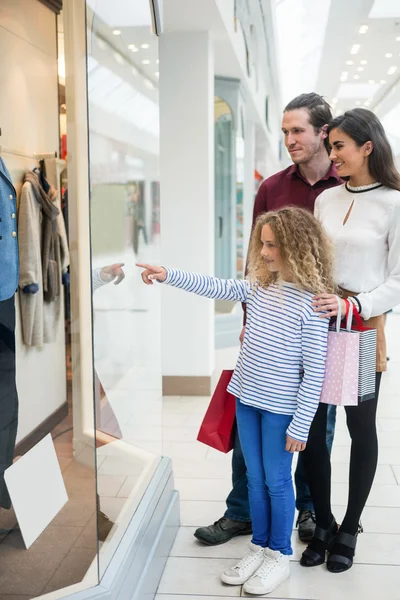 Glad familj stående framför butik — Stockfoto