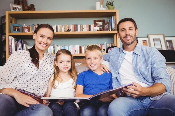 Famiglia con libro seduta sul divano — Foto Stock