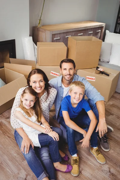 Улыбающаяся семья с картонными коробками — стоковое фото