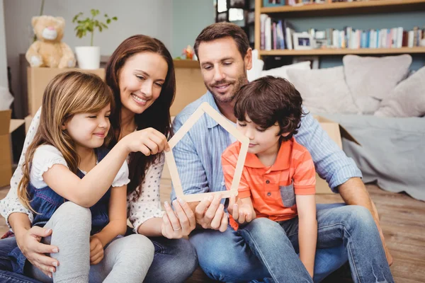 Gülümseyen aile ev şekli tutan — Stok fotoğraf