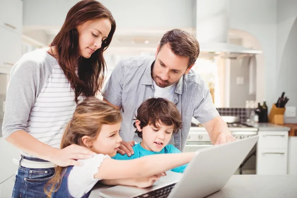 Famiglia che utilizza il computer portatile sul tavolo — Foto Stock