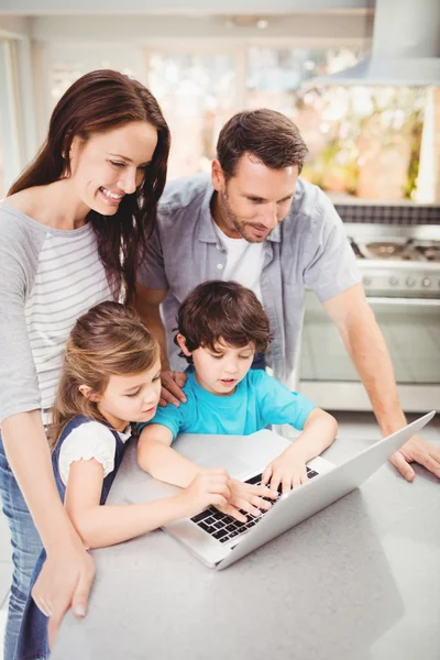 Familia trabajando en el ordenador portátil en la mesa — Foto de Stock