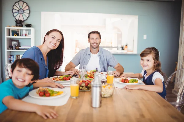 Familie mit Essen am Esstisch — Stockfoto