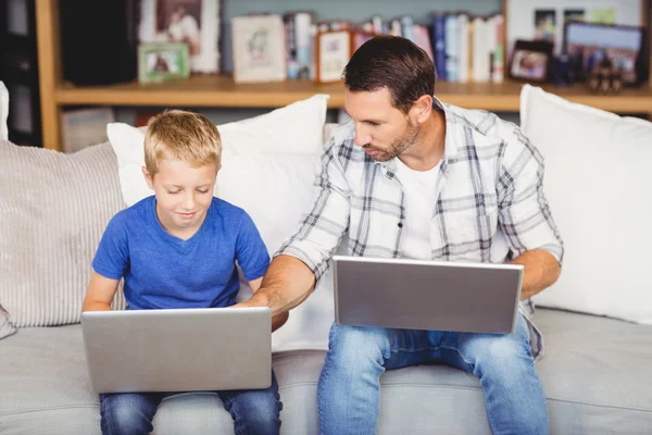 Homem e filho trabalhando em laptops — Fotografia de Stock