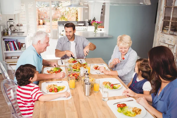 Familia sonriente discutiendo en la mesa de comedor —  Fotos de Stock