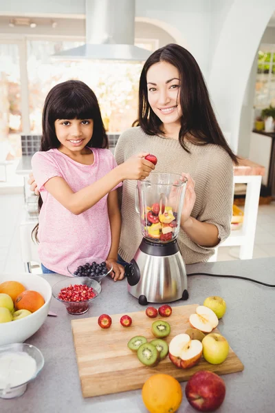 Мать и дочь готовят фруктовый сок — стоковое фото