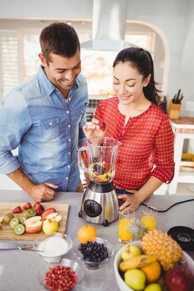Leende par förbereder fruktjuice — Stockfoto