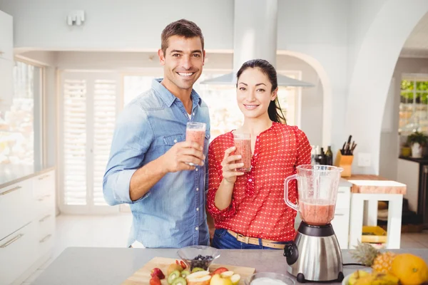 Casal sorrindo segurando suco de frutas — Fotografia de Stock