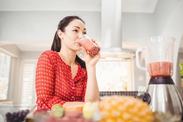 Mulher sorridente bebendo suco de frutas — Fotografia de Stock