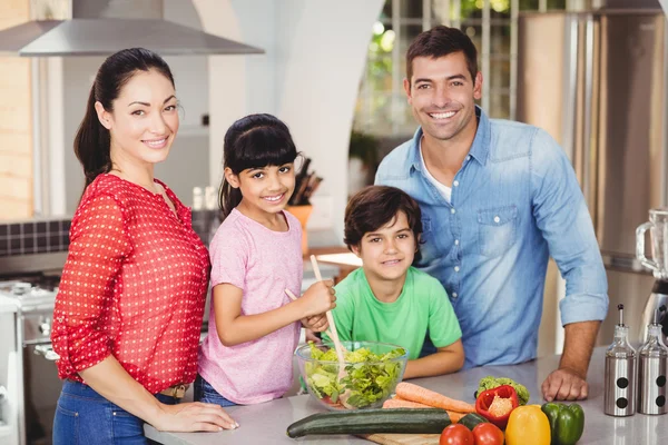 Glückliche Familie bereitet Salat zu — Stockfoto