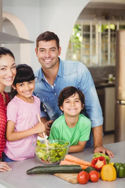Lächelnde Familie bereitet Salat zu — Stockfoto