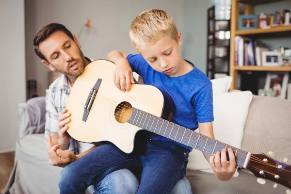 Vader onderwijs zoon om gitaar te spelen — Stockfoto