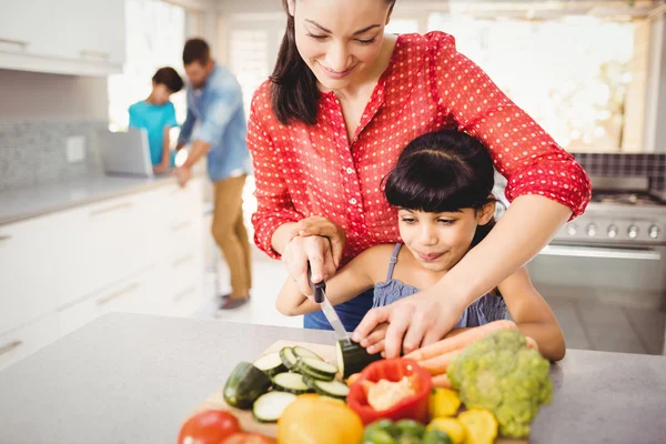 Mor undervisning dotter att skära grönsaker — Stockfoto