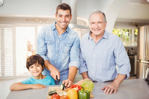 Homem feliz cortando legumes — Fotografia de Stock