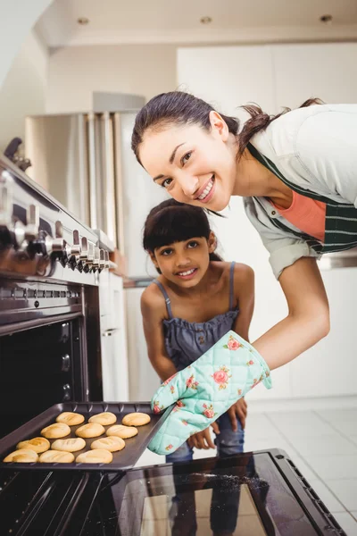 Mulher colocando biscoitos no forno — Fotografia de Stock
