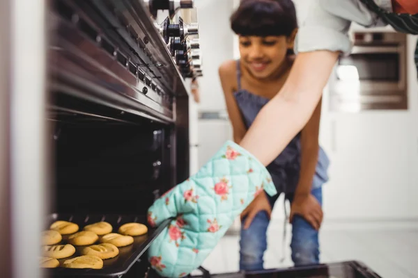 Vrouw cookies plaatsen in de oven — Stockfoto