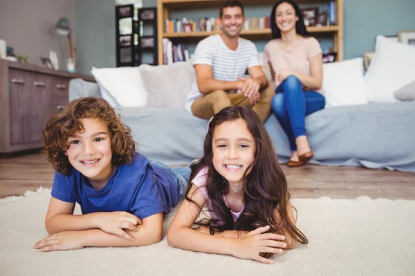 Frères et sœurs couchés sur le tapis — Photo