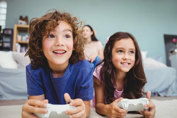 Fratelli e sorelle con controller che giocano ai videogiochi — Foto Stock