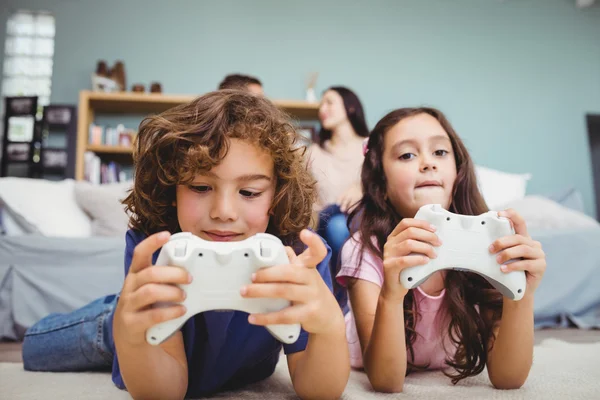 Irmãos com controladores jogando videogame — Fotografia de Stock