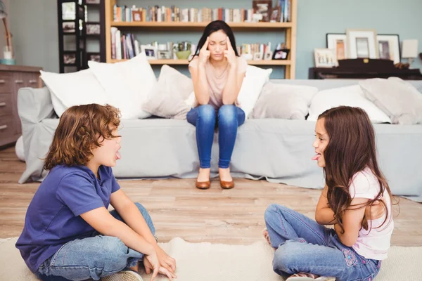 Bambini che giocano mentre la madre è seduta — Foto Stock