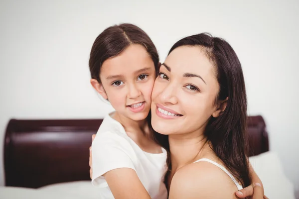 Mother smiling while hugging daughter — Stock Photo, Image