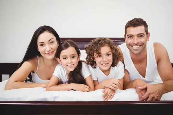 Familjen ligger på sängen hemma — Stockfoto