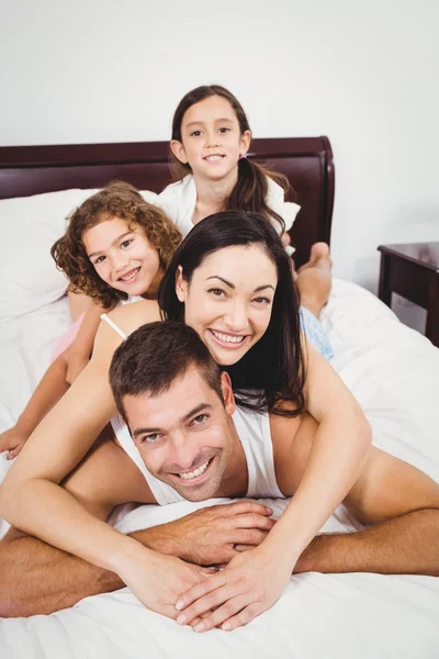 Fröhliche Familie liegt auf dem Bett — Stockfoto