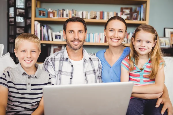 Щаслива сім'я використовує ноутбук вдома — стокове фото