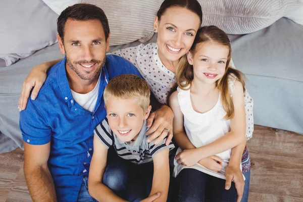 Familia alegre sentada junto al sofá — Foto de Stock