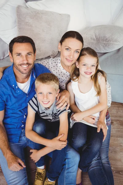 Famiglia felice seduta vicino al divano — Foto Stock