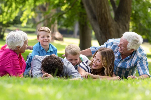 Gülümseyen aile çim yalan — Stok fotoğraf