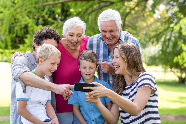 Усміхнена сім'я за допомогою смартфона — стокове фото