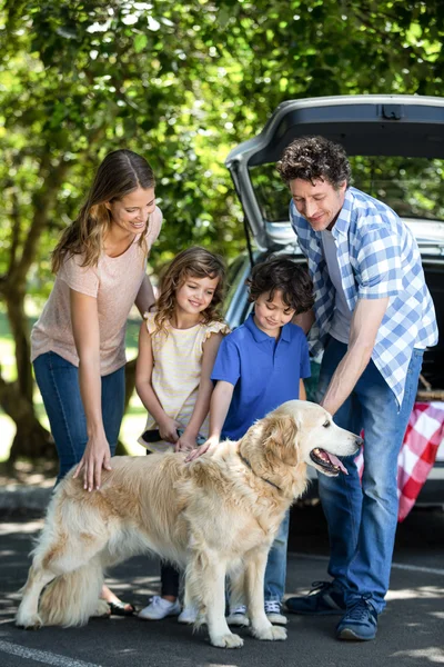 Lachende familie staan voor een auto — Stockfoto
