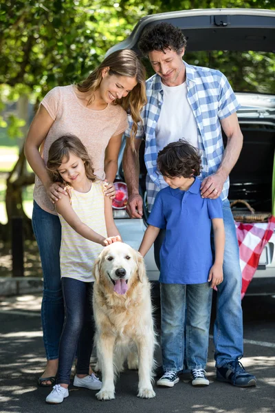 Gülümseyen aile ayakta önünde bir araba — Stok fotoğraf
