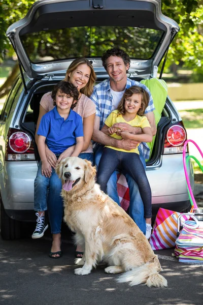 Famiglia sorridente seduta nel bagagliaio — Foto Stock