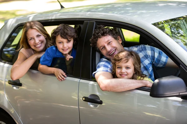 Famiglia sorridente seduta in macchina — Foto Stock