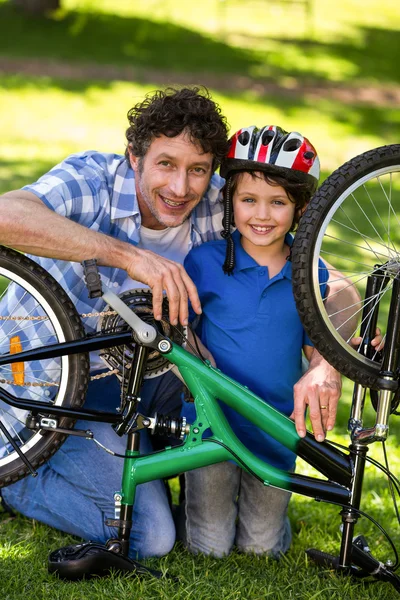 Pai e filho consertando a bicicleta — Fotografia de Stock