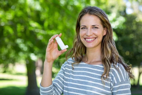 Mujer sonriente sosteniendo inhalador de asma — Foto de Stock