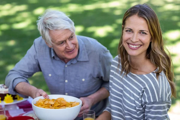 Senior man chips aanbieden aan jonge vrouw — Stockfoto