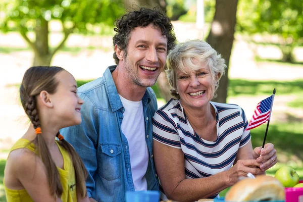 Familia con bandera americana haciendo un picnic —  Fotos de Stock