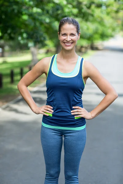 Sportswoman posing with hands on hips — Stock Photo, Image