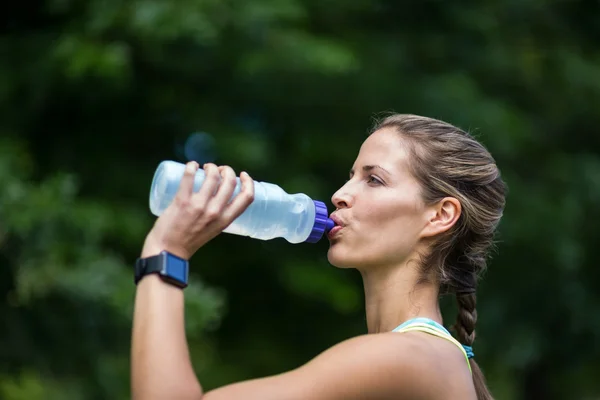 Marathon female athlete running drinking water — Stock Photo, Image