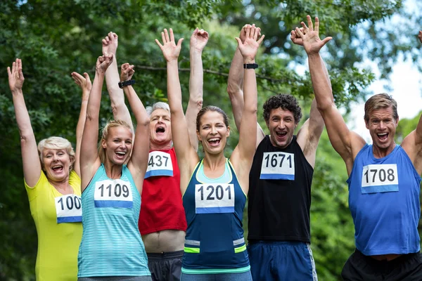 Marathon athletes posing with raised arms — Stock Photo, Image