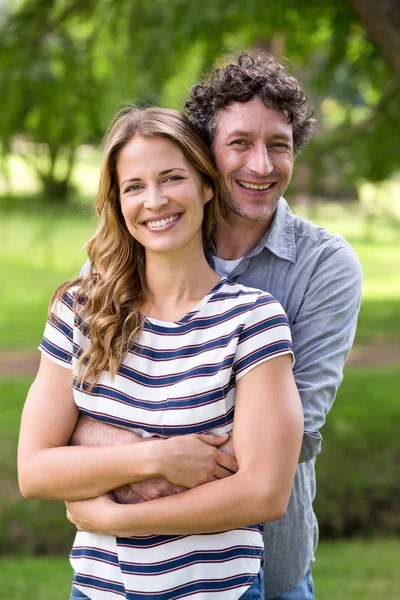 Smiling couple embracing in park — Stock Photo, Image